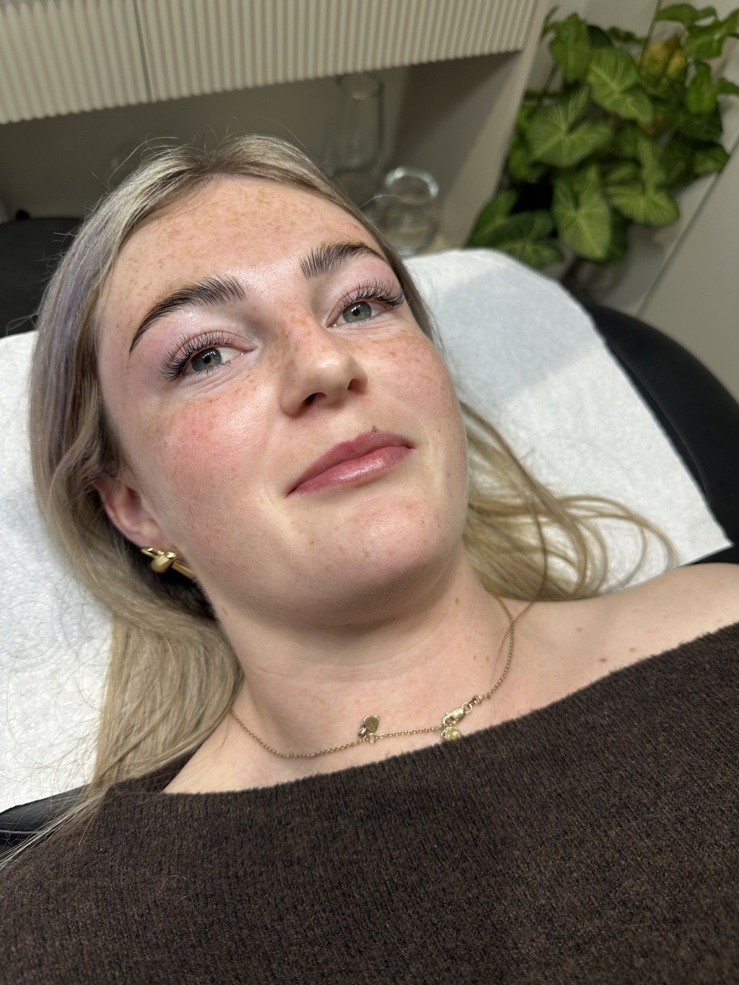 A client lying back on the treatment bed after lash extensions