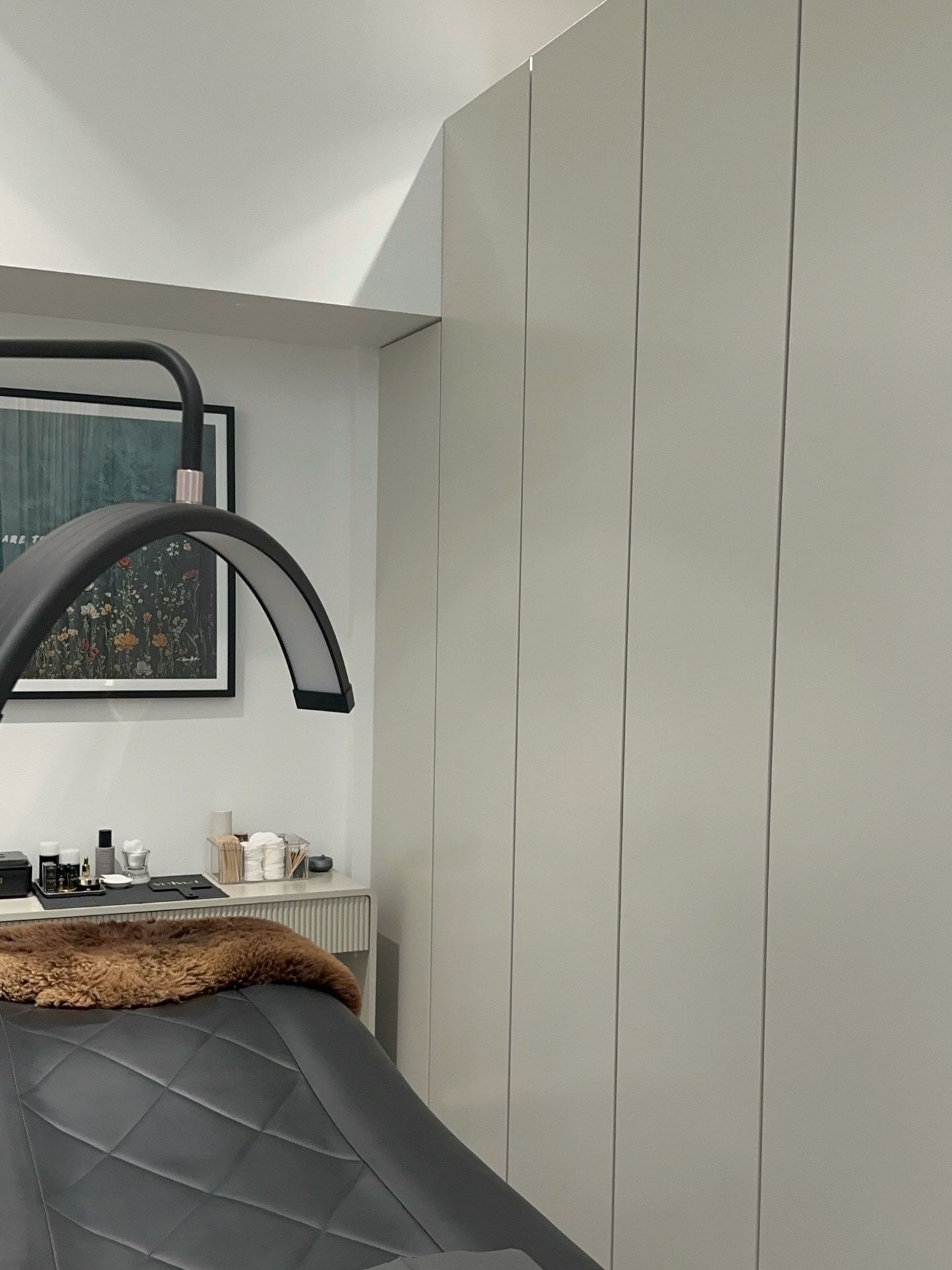 The treatment room at the current studio: the bed, a sheepskin throw and the lash lamp